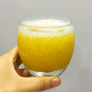 Daissy pineapple passionfruit kombucha in a glass cup, golden bright color, fizzy with lots of small bubbles