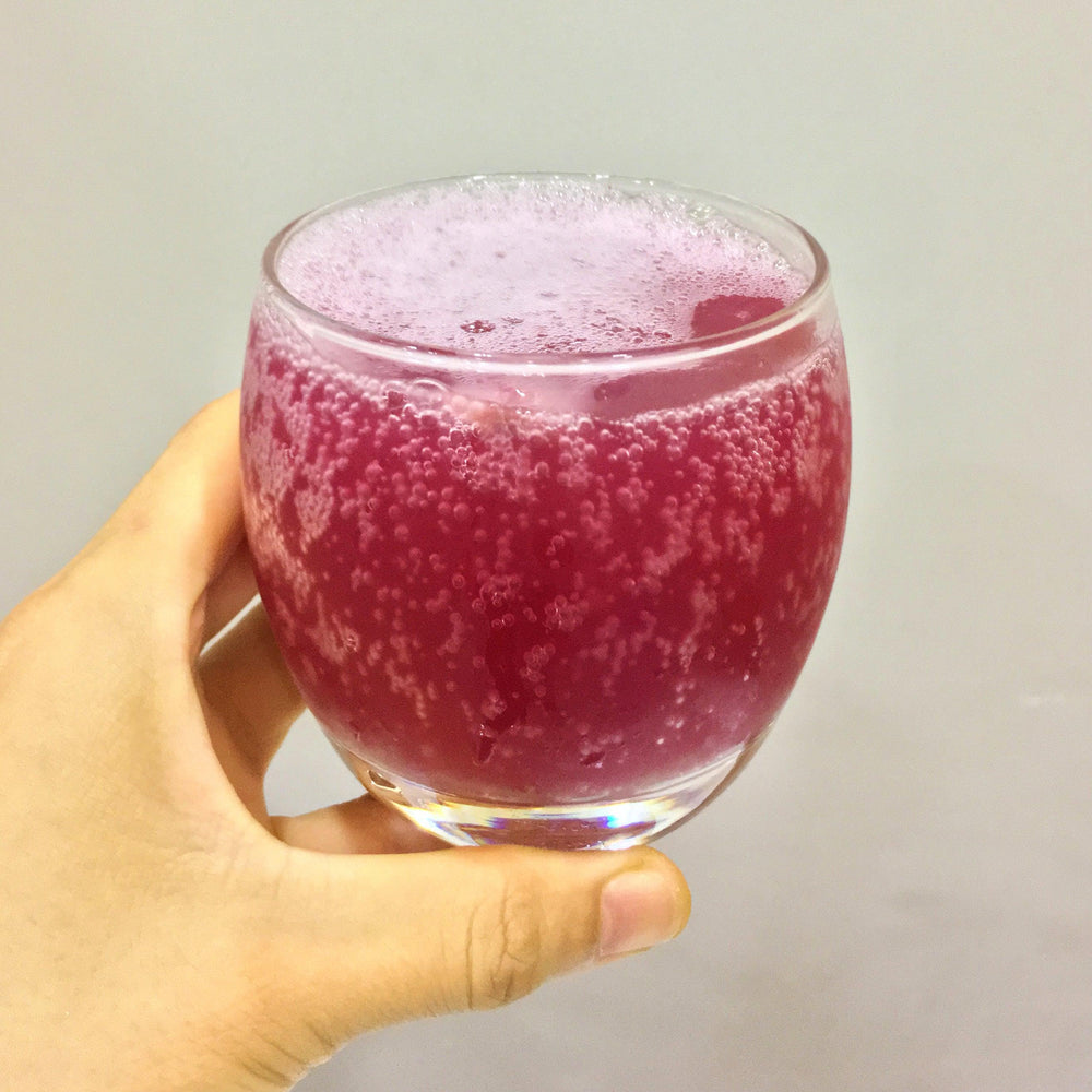 Photo of Daissy grape Kombucha after opening. Full of small bubbles, gorgeous purple color.